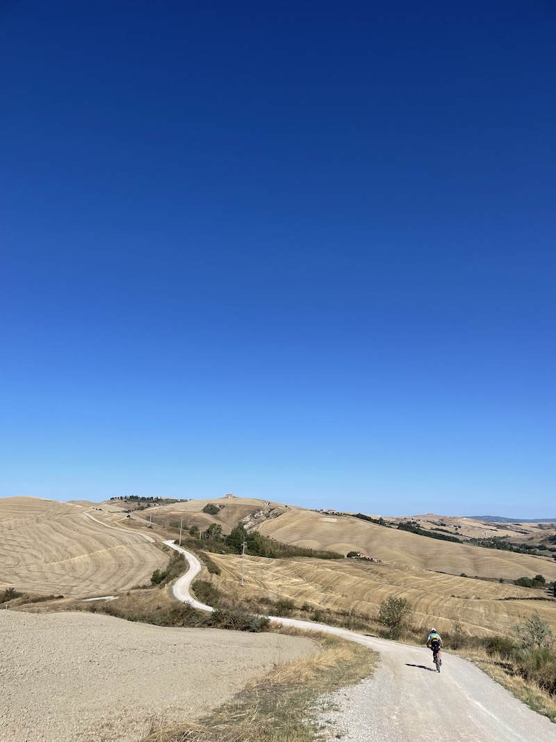 Un ciclista sulle strade bianche dell’Eroica tra le colline toscane