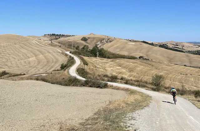 Un ciclista su una strada bianca tra le colline del percorso dell’Eroica in Toscana
